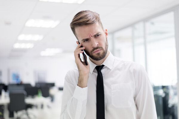 Een man die bezorgd lijkt tijdens een telefoongesprek (Ombudsdienst voor telecommunicatie).