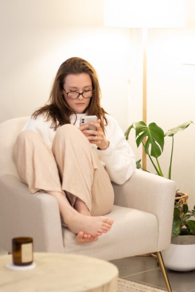 A woman sitting in a chair, using her mobile phone A woman sitting in a chair, using her mobile phone (Office of the Ombudsman for Telecommunications).